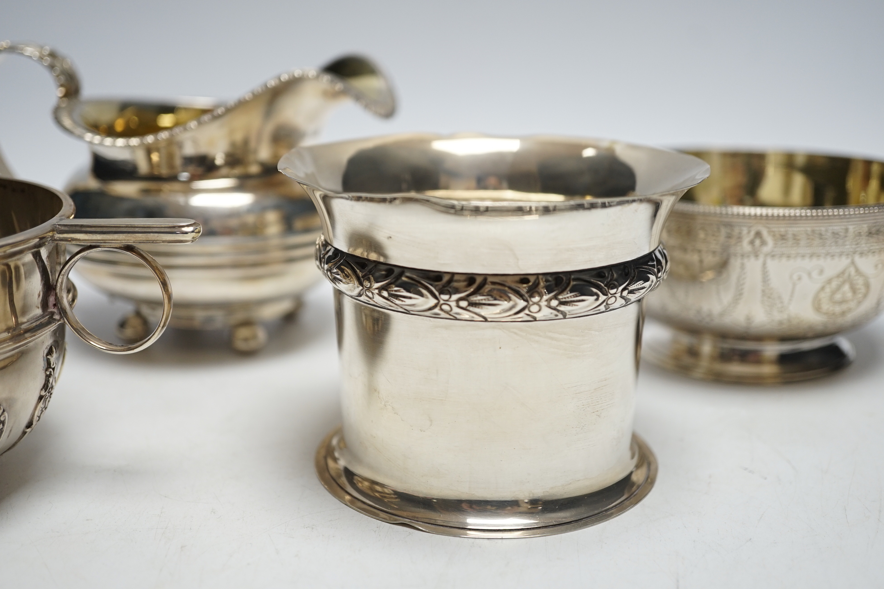 Two silver sugar bowls, London, 1877 and London, 1904, the latter with ring handles, diameter 10.8cm, a silver small vase and a George IV silver cream jug, 21.9oz.